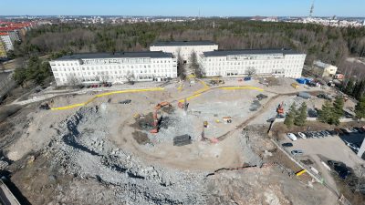 Kolme sairaalarakennusta kuvattuna ilmasta, talojen edessä on työmaa-alue.
