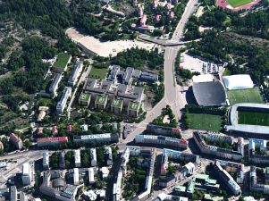 Viistoilmakuva, jossa paljon isoja kerrostaloja vehreässä, puistomaisessa kaupunkimaisemassa.