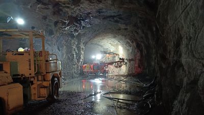 Kaksi työkonetta työskentelee pimeässä tunnelissa.
