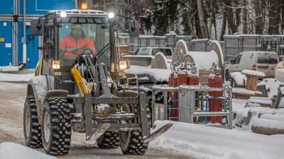 Pyöräkuormaaja ajaa työmaan varastoalueella.